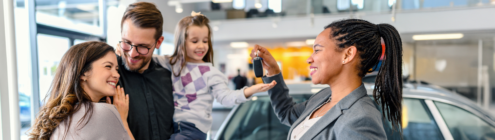 Family receiving keys to their new car